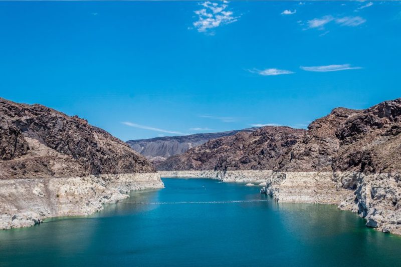 Lake Mead surrounded by boulders under a blue sky