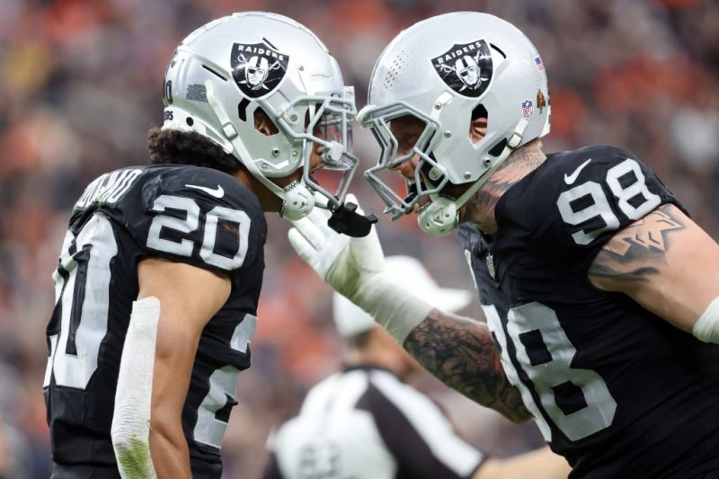 Isaiah Pola-Mao #20 of the Las Vegas Raiders reacts after a sack with Maxx Crosby #98 during the second quarter in the game against the Denver Broncos at Allegiant Stadium on January 07, 2024 in Las Vegas, Nevada.