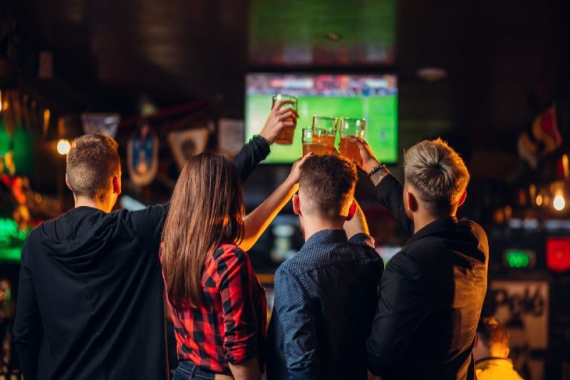 People cheersing at a sports bar.