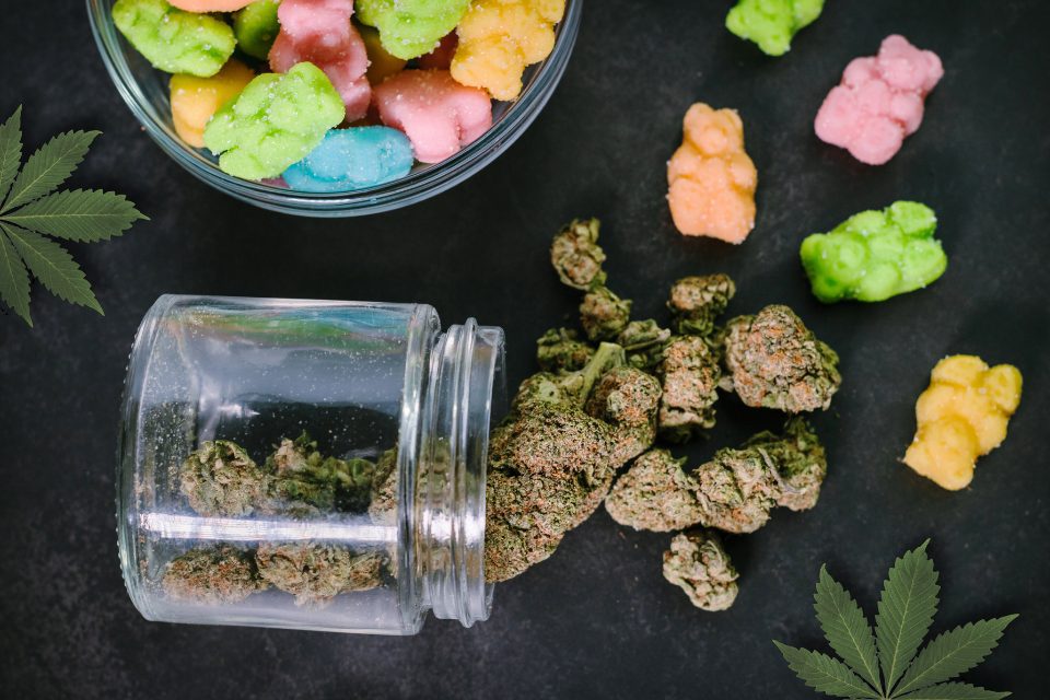 Marijuana flower and colorful edible candies.