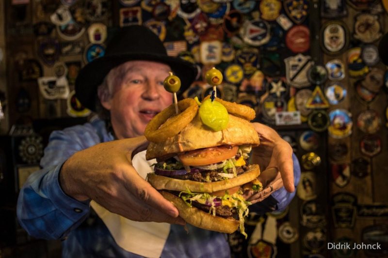 Man holding a massive cheesburger.