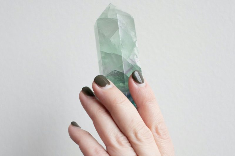 Hand holding light turquoise gem.