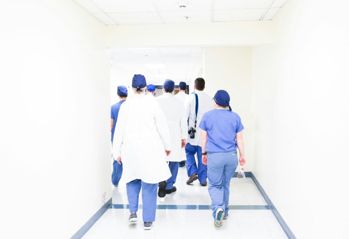 A group of medical professionals walking down a hallway.