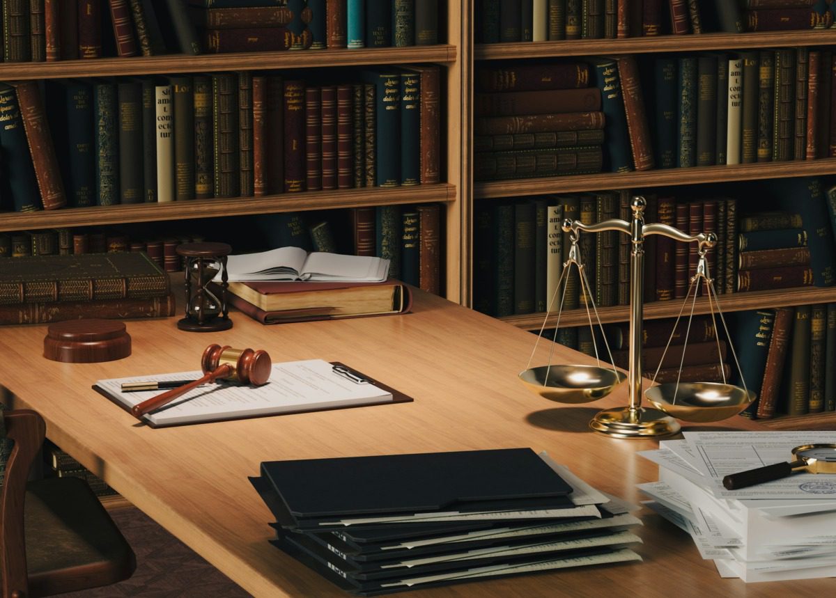 Assorted legal items on a wooden desk in a library.