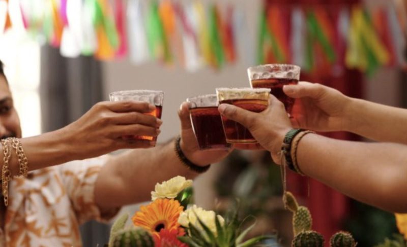 hands holding glasses of booze